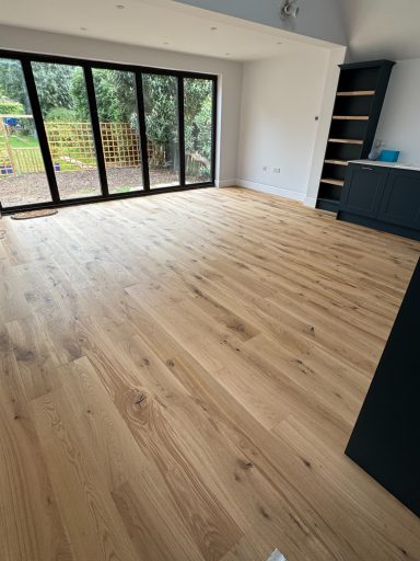 Light-filled interior with wooden flooring and large glass doors to the garden.